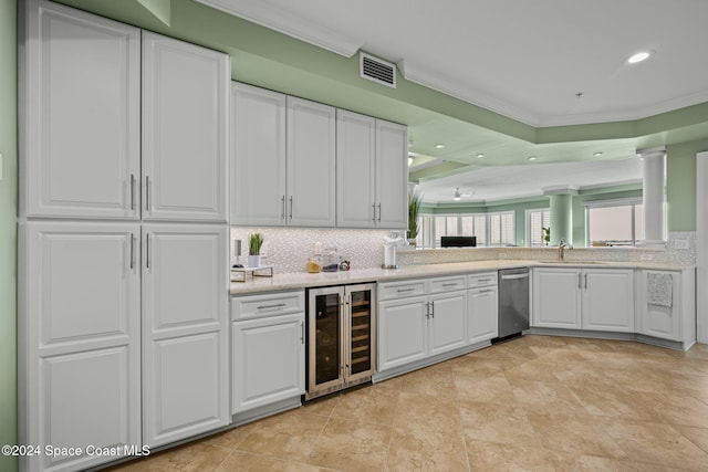 kitchen with wine cooler, sink, crown molding, white cabinets, and tasteful backsplash