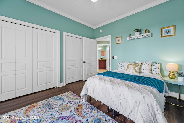 bedroom with crown molding, multiple closets, dark hardwood / wood-style flooring, and ceiling fan