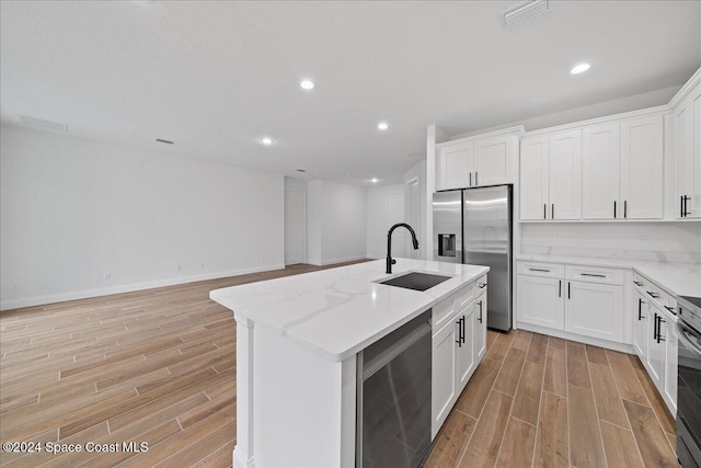 kitchen with a center island with sink, stainless steel appliances, light hardwood / wood-style floors, and sink