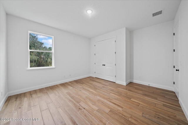 unfurnished bedroom featuring light wood-type flooring and a closet