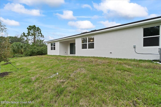 back of house featuring a lawn