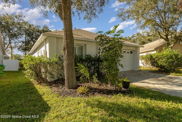 view of front of home with a front yard and a garage