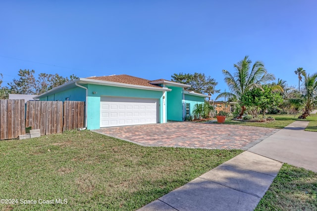 single story home featuring a front lawn and a garage