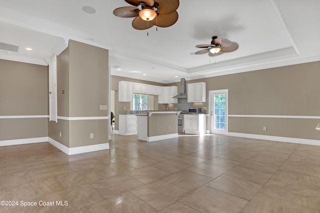 unfurnished living room with ornamental molding, a tray ceiling, and ceiling fan