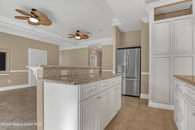 kitchen with a center island, stainless steel refrigerator with ice dispenser, white cabinetry, and ceiling fan