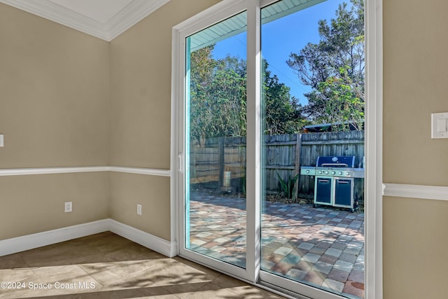 doorway featuring crown molding and baseboards