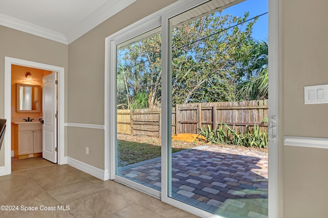 doorway to outside with ornamental molding and sink