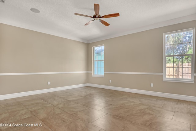 empty room featuring baseboards, a ceiling fan, and a textured ceiling