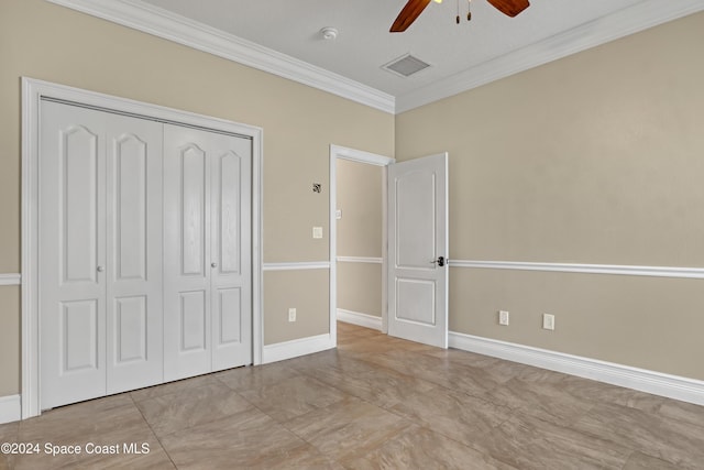 unfurnished bedroom featuring a closet, ornamental molding, ceiling fan, baseboards, and visible vents