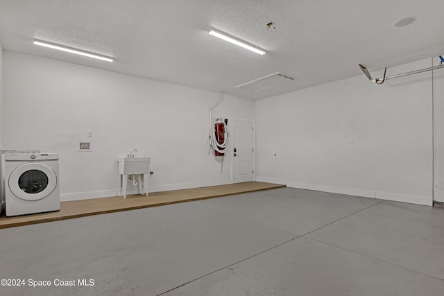 garage with a sink, baseboards, and washer / clothes dryer