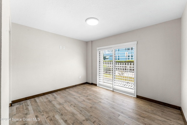 empty room featuring baseboards and wood finished floors