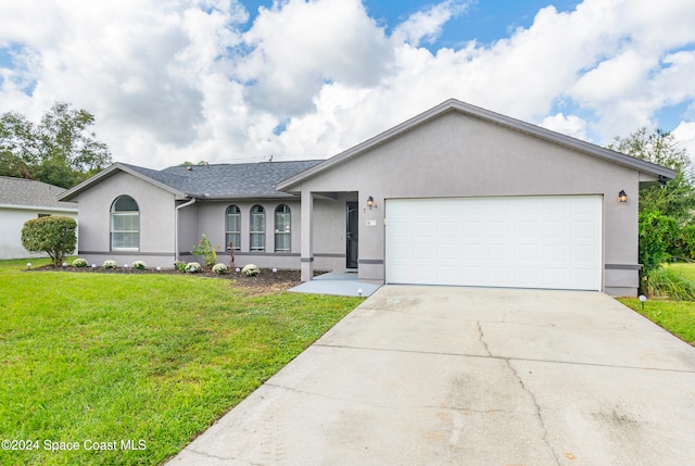 ranch-style house featuring a front lawn and a garage