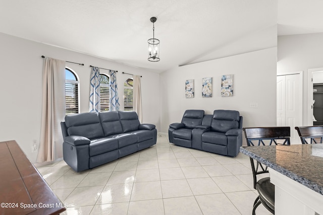 living room with a chandelier, vaulted ceiling, and light tile patterned floors