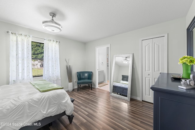 bedroom with a textured ceiling, a closet, ceiling fan, connected bathroom, and dark hardwood / wood-style floors