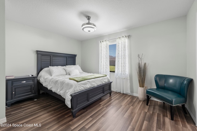 bedroom featuring a textured ceiling and dark hardwood / wood-style flooring