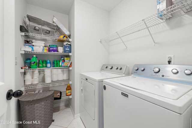 clothes washing area with separate washer and dryer and light tile patterned floors