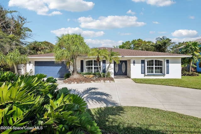 ranch-style house featuring a front yard and a garage