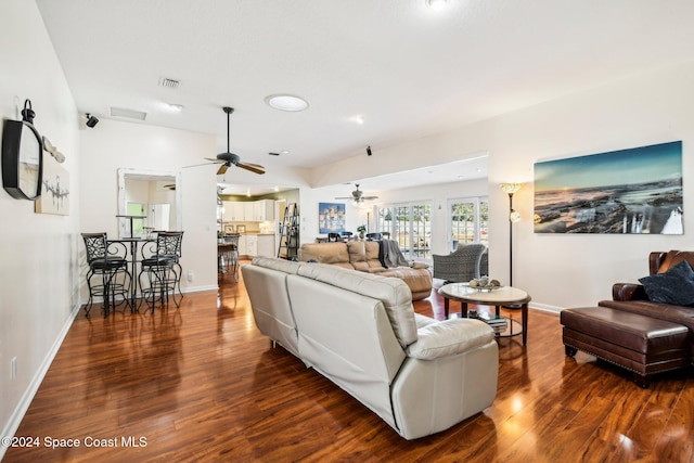 living room with dark wood-type flooring and ceiling fan