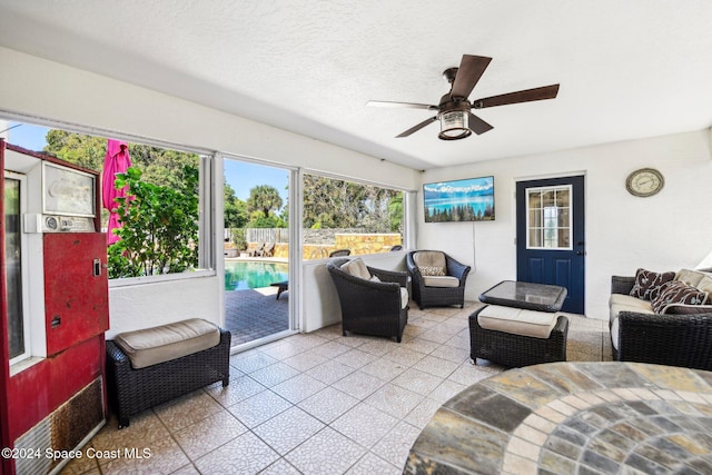 living room featuring ceiling fan, a textured ceiling, and light tile patterned floors