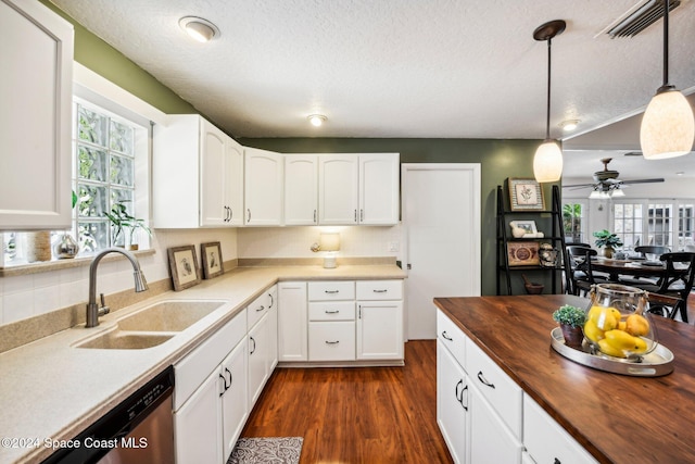 kitchen with butcher block countertops, hanging light fixtures, a wealth of natural light, and white cabinets