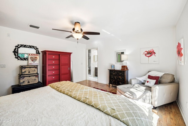 bedroom with hardwood / wood-style flooring, connected bathroom, and ceiling fan