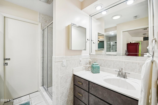 bathroom featuring vanity, tile walls, tile patterned flooring, and an enclosed shower