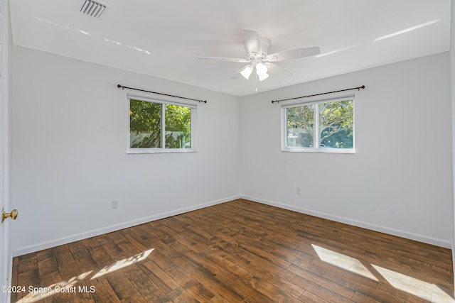 unfurnished room featuring ceiling fan, dark hardwood / wood-style floors, and plenty of natural light