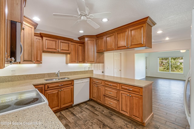 kitchen with dishwasher, sink, dark hardwood / wood-style flooring, light stone counters, and ceiling fan