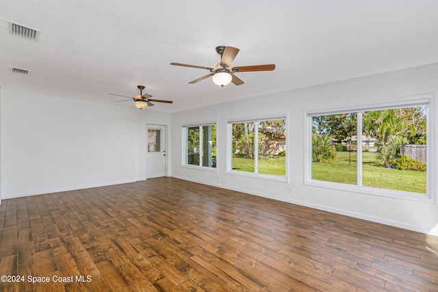 spare room with dark wood-type flooring and ceiling fan