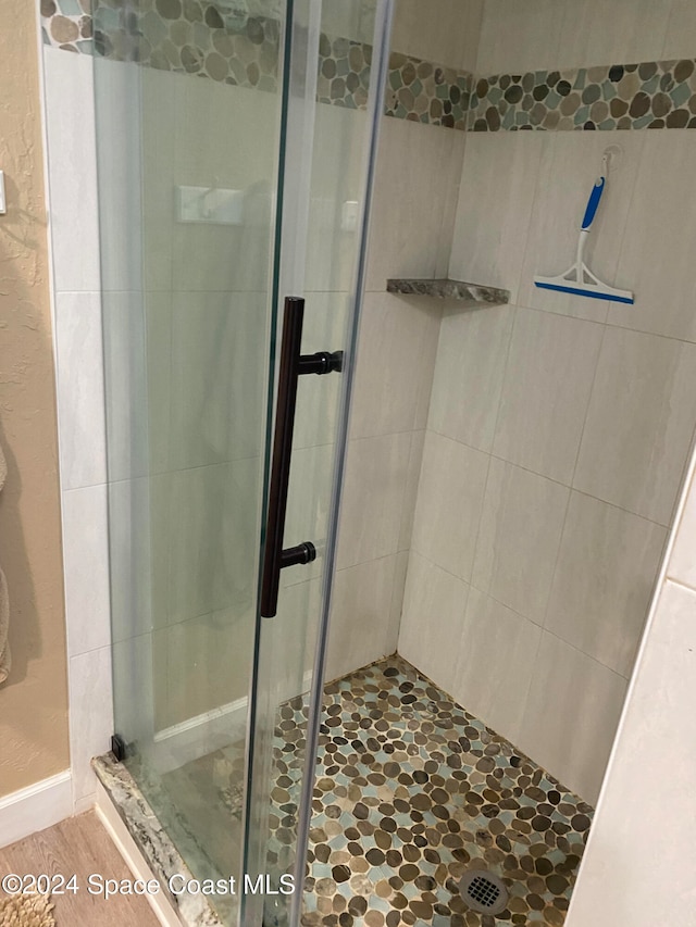 bathroom featuring wood-type flooring and walk in shower