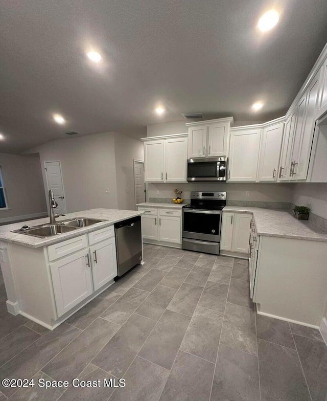 kitchen featuring white cabinets, a textured ceiling, a kitchen island with sink, sink, and stainless steel appliances