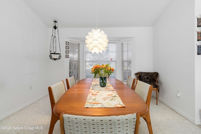 dining area featuring carpet and an inviting chandelier