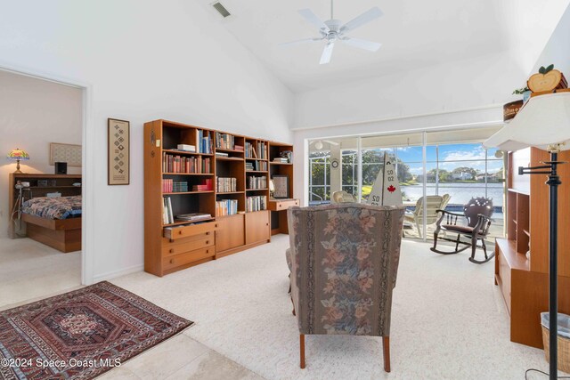 sitting room with light carpet, high vaulted ceiling, a water view, and ceiling fan