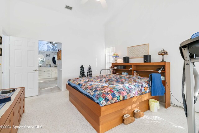 bedroom featuring light carpet, multiple windows, a towering ceiling, and ceiling fan