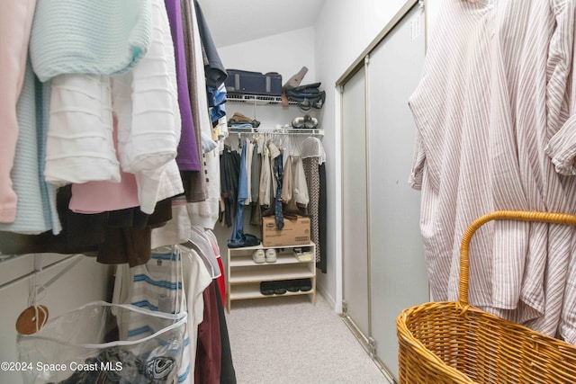 walk in closet with lofted ceiling and carpet floors