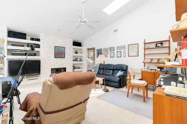 carpeted living room with ceiling fan, a stone fireplace, high vaulted ceiling, and built in shelves