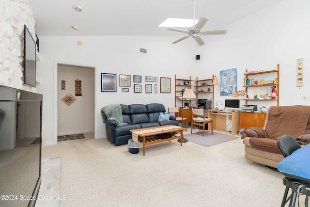 living room with ceiling fan, high vaulted ceiling, a skylight, and light colored carpet