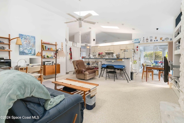 living room with a skylight, light carpet, high vaulted ceiling, and ceiling fan