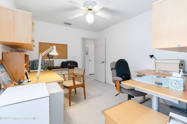 carpeted office space featuring ceiling fan