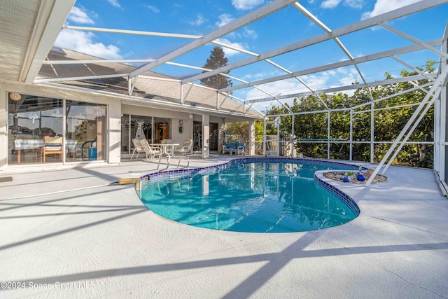 view of pool with a patio area and glass enclosure