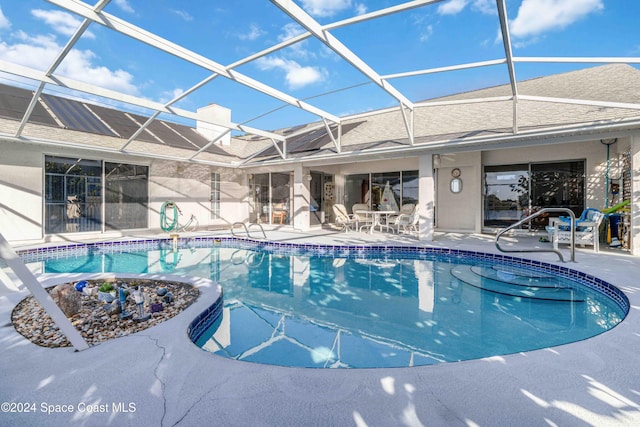 view of swimming pool with a patio area and glass enclosure