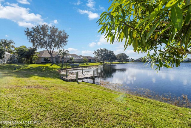 view of dock with a water view and a lawn