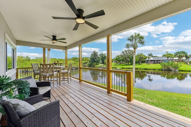 deck with a lawn, a water view, and ceiling fan