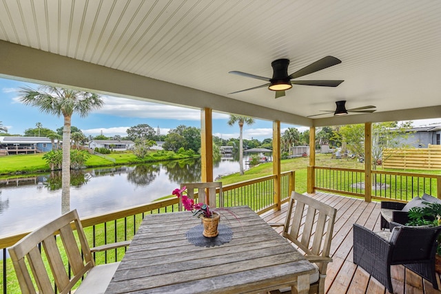 deck featuring a lawn, a water view, and ceiling fan