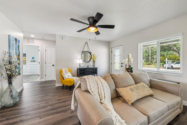 living room featuring dark wood-type flooring and ceiling fan