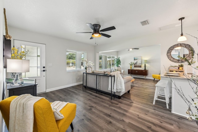 living room featuring dark wood-type flooring and ceiling fan