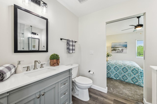 bathroom featuring vanity, hardwood / wood-style flooring, toilet, and ceiling fan