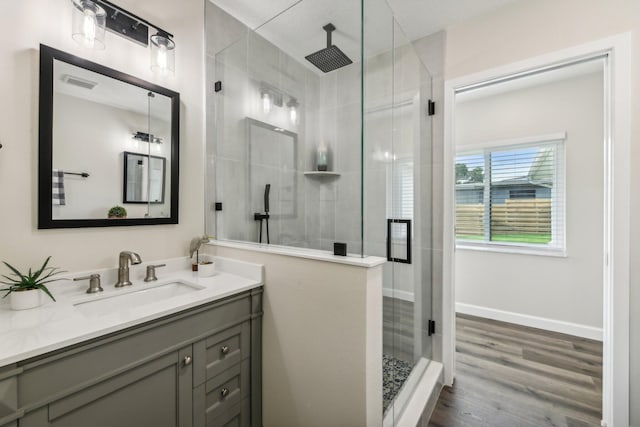 bathroom featuring vanity, hardwood / wood-style floors, and walk in shower