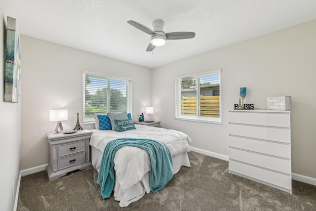 carpeted bedroom featuring ceiling fan, a textured ceiling, and multiple windows