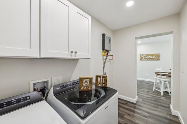 clothes washing area featuring dark wood-type flooring, cabinets, and washing machine and clothes dryer